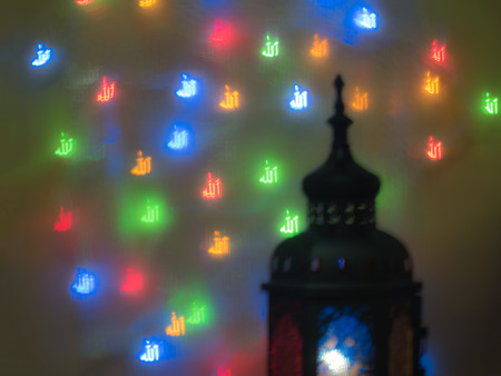 blur ramadan lantern on defocused of the name of God "Allah" in arabic textの写真素材