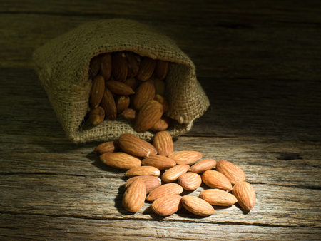 created shot of almonds on wooden background in studioの写真素材