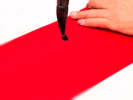 brush with black ink, write with traditional chinese calligraphy art text, on red paper.の写真素材
