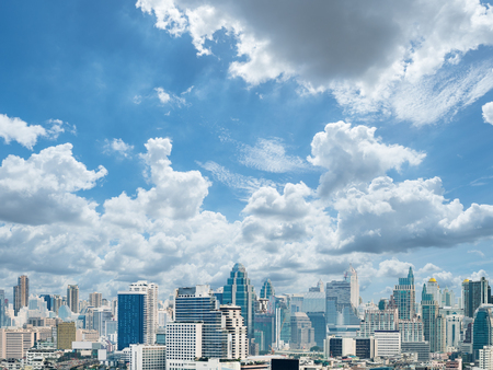 abstract background exterior view looking toward to the cloudy sky with full of light , against cityscape with many buildingの写真素材