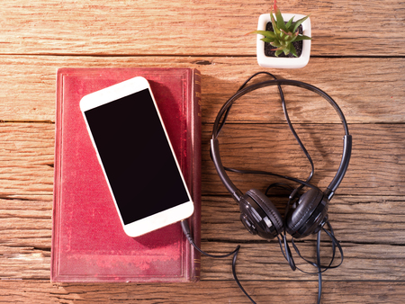 smartphone with ears plug head phone placed on aged wooden backgroundの写真素材