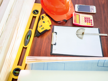 engineering and architect workplace with measurement equipments and roll of blueprint on table, soft...