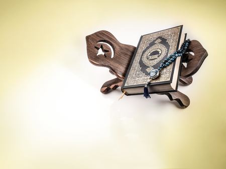 Quran or Kuran, the islamic holy book of all muslim in white background with rosary bead on wooden standの写真素材