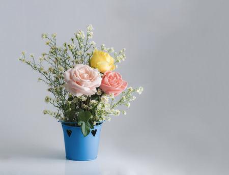 Bouquet of fresh rose flower in a white enameled vintage on white table, rustic home decoration backgroundの写真素材