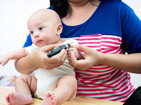 diabetes test on baby finger, motherhood conceptの写真素材
