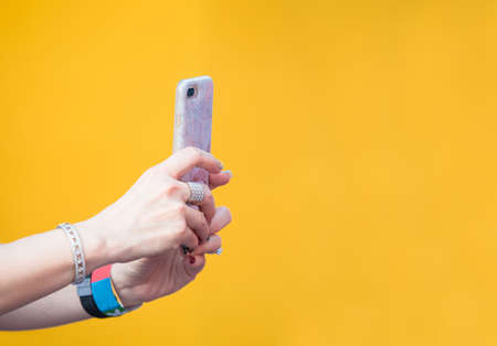 smart phone on woman hands in brigth yellow background, life style in the city