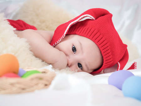 cute asian four-month baby in red dress sleeping in easter festival. Happy easter concept.の写真素材