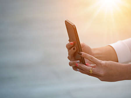young girl's hands holding smartphone to take photos of something,  the activity of camera man's hobby lifestyle in city by using back camera of  smart phone.の写真素材