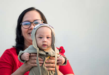 cute asian five-month baby in traditional dress smiling with his mother chinese newyear festival....