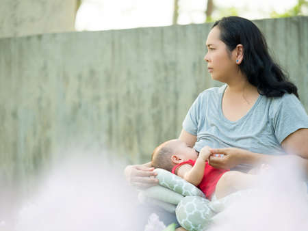 cute asian six-month baby in traditional dress smiling with his mother chinese newyear festival....