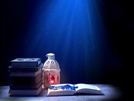 Quran or Kuran ( the islamic holy book) on black background with rosary bead ready to read in...