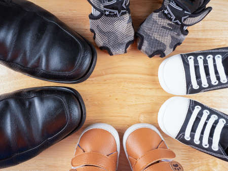 lovely baby shoes on wooden background with his father's boot, prepare for baby concept.