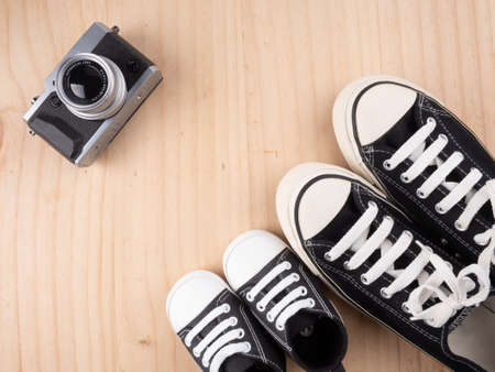 lovely baby shoes on wooden background with decoration camera to travel , prepare for baby concept.