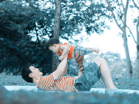 Close up shot of cute asian baby in lovely actions in the outdoor nature, health care and fatherhood concept.の写真素材