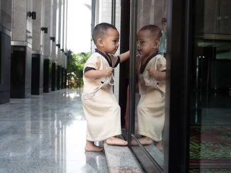 cute child in toddler age with lovely action, doing something to develop his movement skill,...