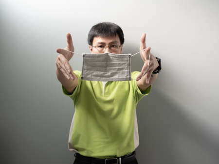 Asian man wearing white face mask to prevent Coronavirus,which official name for Coronavirus disease...