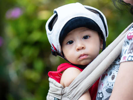 cute baby newborn in red dress and head guard with lovely action, motherhood conceptの写真素材