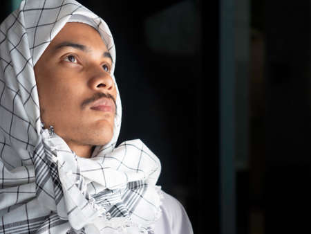 portrait of young Muslim man in traditional dress ready to whorship, showing his faith in  Allah (Muslim God)の写真素材