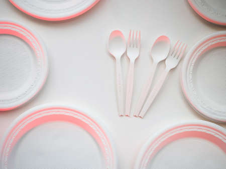 degradable plastic forks and spoons and disks arranged on white background, to protect environment...