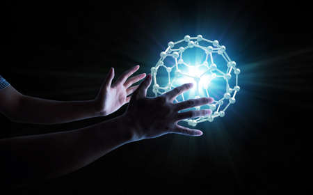 human hands handle energy ball with orbis cage to retain light burst, scientific conceptの写真素材