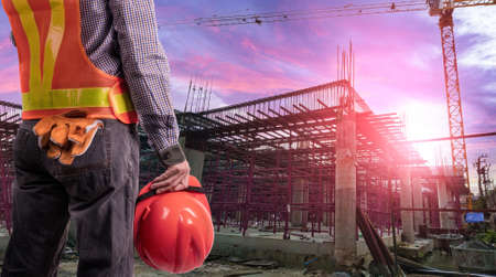 a worker man on standing action with protective equipment on sunset sky background