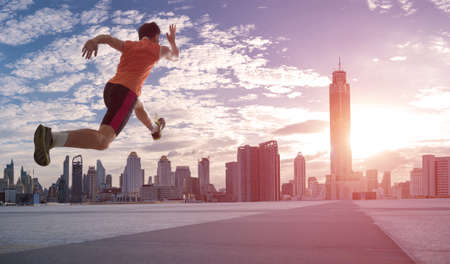 a man as athlete runner in high speed running action on the road toward the sunrise with bright sky backgroundの写真素材
