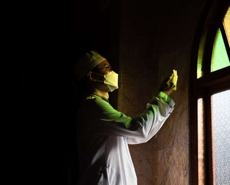 Muslim man with fully traditional white dress praying for Allah, Muslim God, on mosque in ramadan kareem night.の写真素材