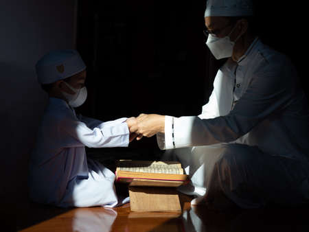 Muslim man with fully traditional white dress praying for Allah, Muslim God, on mosque in ramadan kareem night.の写真素材