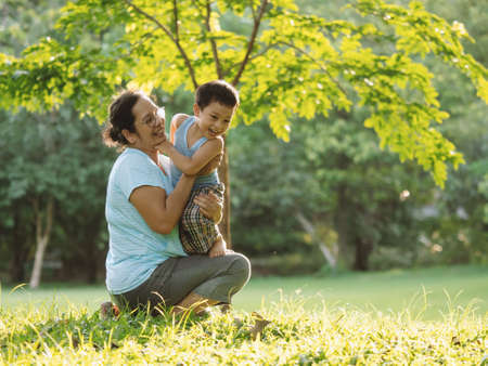 An asian boy playing outdoor with his mother on excited activity with happy life on happy time, learning via outdoor activity concept, child will going to large world to grow up in the future.の写真素材