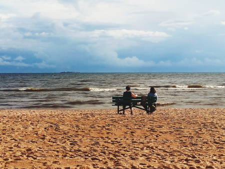 Two women sitting on a beachの写真素材
