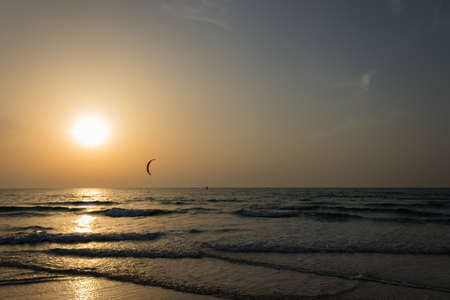 Surfer do surfing at the sunset time. Amazing sunset at the beach.  Evening time. Closeup water.