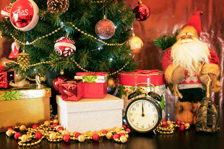 Decorative Christmas decorations close-up. Hanging ornaments on the fake pine tree. Christmas gift...