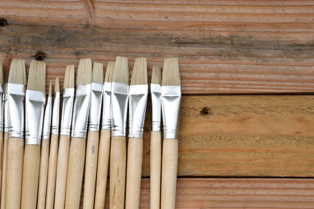 row of artist paintbrushes closeup on old woodenの写真素材