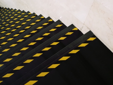 Yellow line on the black step. Warning color at staircase.の写真素材