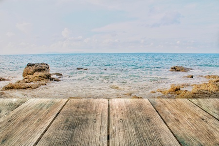 Wood board on rock beach and blue sea, used for montage or display products