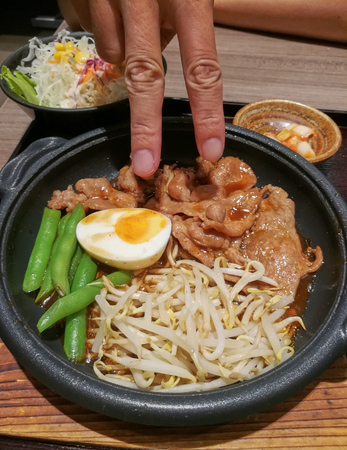 Japanese Barbecue in Thai Style. Finger try to stab on the food.の写真素材