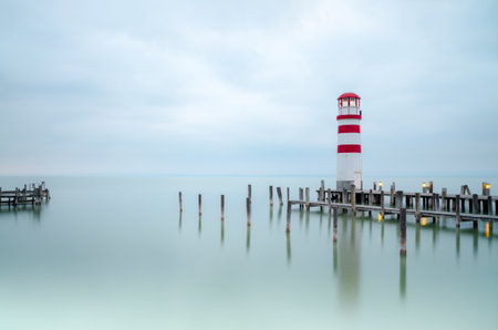 Lighthouse in the sea with cloudy sky background. Long exposure.の写真素材