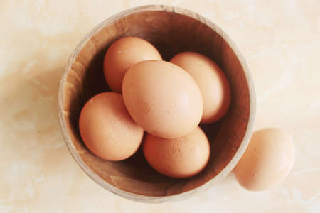 eggs in a wooden bowlの写真素材