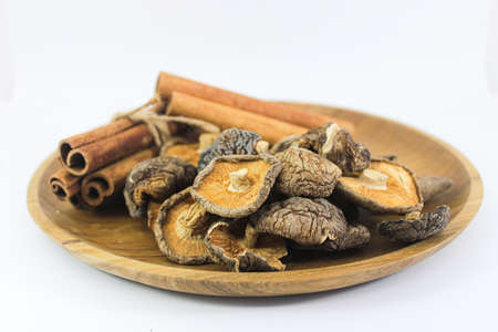 Close up Shitake Mushroom and Cinnamon in wood plateの写真素材