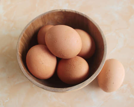 eggs in a wooden bowlの写真素材