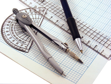 A compass,pen,protractor & ruler on a sheet of graph paper.の写真素材