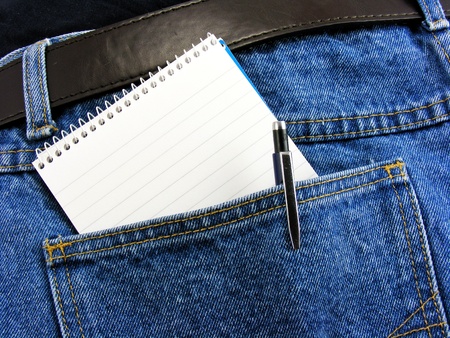 A blank notebook & pen in dark denim jeans pocket