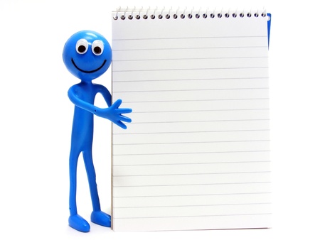 happy figure standing next to a blank lined spiral bound notebook with copy spaceの写真素材