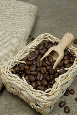 Fresh coffee beans in a basket with wooden scoopの写真素材