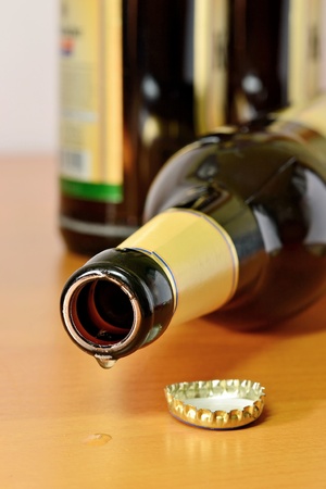 An empty beer bottle lying dripping on a tableの写真素材