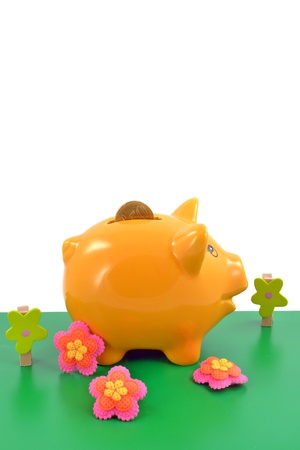 Piggy bank on a toy garden background with copy spaceの写真素材