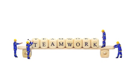 Teamwork concept with builders and wooden letter blocksの写真素材