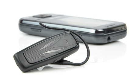 A bluetooth headset and mobile cell phone on white background