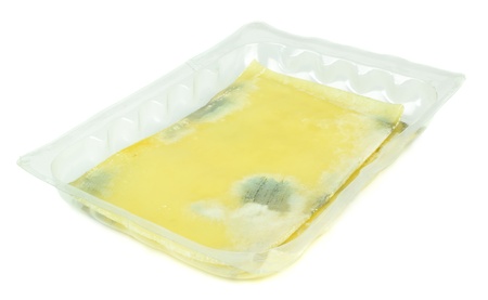 Slices of rotten mouldy cheese on a white background