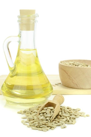 A bottle of sunflower oil with seeds on white backgroundの写真素材